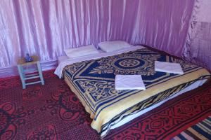 a bed in a room with a pink tent at Sahara Berber Camp - Mhamid Discovery Camp in Mhamid el Rhozlane