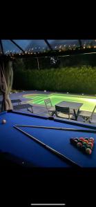 una mesa de billar con dos cuesticks encima en BY NEPTUNE - La Villa Courtenay Piscine Privée en Courtenay