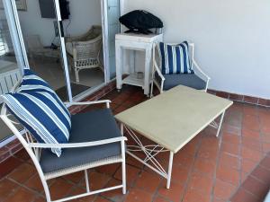 a room with chairs and a table and a table at Palm Cove - 52 Chakas Cove, Penthouse-Literally on the Beach in Ballito