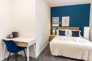een slaapkamer met een bureau en een bed en een bureau en een bed bij Suite 5 - Stylist Spot in Oldham City Centre in Oldham