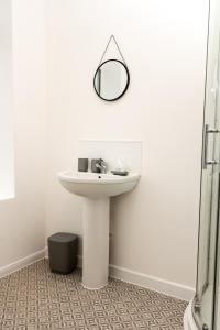 a bathroom with a sink and a mirror on the wall at Suite 5 - Stylist Spot in Oldham City Centre in Oldham