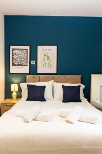 a bedroom with a large bed with a blue wall at Suite 5 - Stylist Spot in Oldham City Centre in Oldham