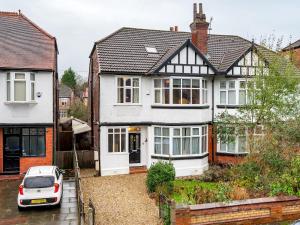 a white car parked in front of a house at Pass the Keys Spacious 5 Bed House Sleeps up to 12 in Manchester