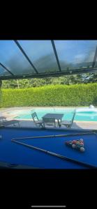 a pool table with two chairs and a ping pong ball at BY NEPTUNE - La Villa Courtenay Piscine Privée in Courtenay