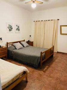 een slaapkamer met 2 bedden en een plafondventilator bij El Cencerro - casa de campo - Tomas Jofre in Tomás Jofré