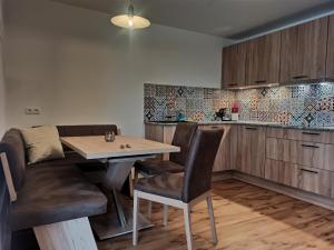a kitchen with a table and chairs in a room at Stefflgut Appartements in Maishofen