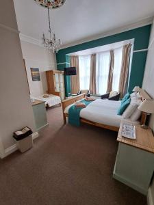 a bedroom with a large bed and a window at Hildebrand Guest House in Tenby