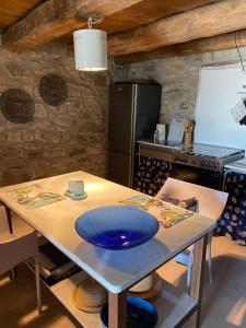 una cocina con una mesa con una placa azul. en Sotto il fico en Agnino