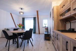 - une cuisine et une salle à manger avec une table et des chaises dans l'établissement Apartament Kawałek Podłogi, à Piechowice