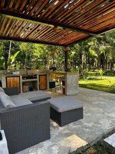 un patio con sofás y una pérgola de madera en La Amapola Lodge, Bungalow en Península de Osa. en Barrigones