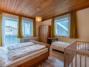 two beds in a room with windows and a staircase at Holiday Home Pilz II - SLD510 by Interhome in Rohrmoos