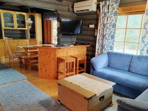 uma sala de estar com um sofá azul e uma televisão em Holiday Home Sinisorsa by Interhome em Rutalahti