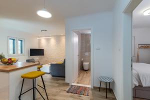 1 dormitorio y sala de estar con cama y escritorio. en A3 apt with balcony and sea view 3 min to beach, en Trogir