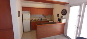 cocina con armarios de madera y nevera blanca en FMSHOUSEdos en Villa Santa Cruz del Lago