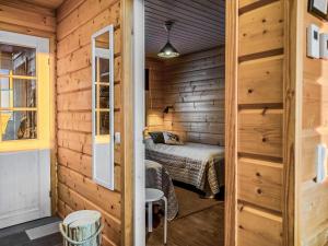 a bedroom with a bed in a wooden cabin at Holiday Home Napakettu by Interhome in Saariselka