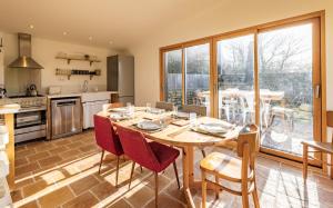 cocina y comedor con mesa y sillas en Maison pour 4 personnes proche de La Torche en Plomeur