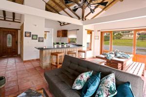 a living room with a couch and a kitchen at Casa de las Flores- Chalet Privado in Villa de Leyva