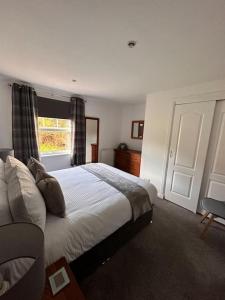 a bedroom with a large bed and a window at Apartment in Queens Court, Banchory in Inchmarlo
