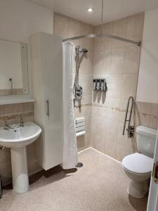 a bathroom with a shower and a toilet and a sink at Apartment in Queens Court, Banchory in Inchmarlo