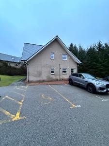 a car parked in a parking lot in front of a house at Apartment in Queens Court, Banchory in Inchmarlo
