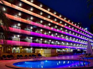 a building with a pool in front of it at night at Hotel Servigroup Diplomatic in Benidorm