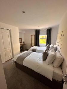 a large bedroom with two beds and a window at Apartment in Queens Court, Banchory in Inchmarlo