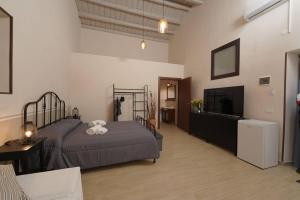 a bedroom with two beds and a flat screen tv at Antica Dimora Siracusa in Arenella