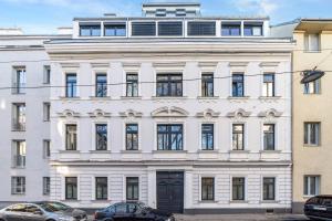 um edifício branco com carros estacionados em frente em Vienna Chic Residences #Suite 6 * Brand New * em Viena