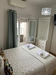Hostal Flat55Madrid في مدريد: غرفة نوم بسرير كبير عليها مناشف