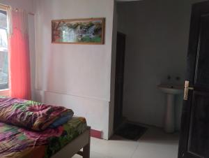 een kamer met een bed en een wastafel bij MATRONA in Bajawa