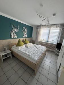 - une chambre avec un lit et un mur bleu dans l'établissement 50107 Ferienhaus Cliner Sünn Whg. Borkum, à Carolinensiel