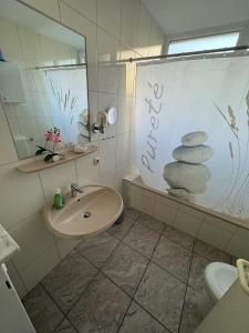 La salle de bains est pourvue d'un lavabo et d'un miroir. dans l'établissement 50107 Ferienhaus Cliner Sünn Whg. Borkum, à Carolinensiel