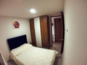 a small bedroom with a bed and a mirror at Apto Increíble en ubicación privilegiada. in Ibagué
