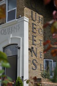 a sign on the side of a building with a door at Queens Hotel in London