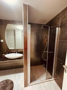 a bathroom with a sink and a shower at Vodno Apartment Skopje in Skopje