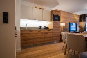 a kitchen with wooden cabinets and a table with chairs at Charming three-room apartment in Huez - Welkeys in LʼHuez