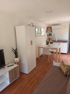 a living room with a white refrigerator and a table at CABAÑA MOAI in Mar del Plata