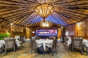 un restaurante con mesas y sillas y un gran techo en Vientos del Caribe Club & Hotel en El Yaque