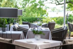 um grupo de mesas com toalhas de mesa brancas e flores em Romantik Hotel Kieler Kaufmann em Kiel