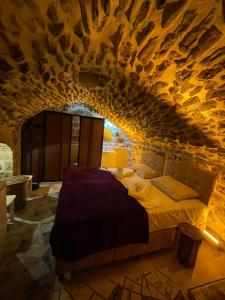 ein Schlafzimmer mit einem Bett in einer Steinmauer in der Unterkunft Aydınbey konagı in Mardin