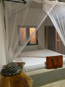 a bedroom with a bed with white mosquito netting at Hiriketiya Collection in Dickwella