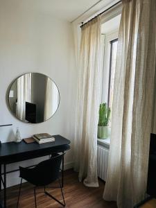 a room with a desk and a mirror and a window at LOFT MANZONI 37 in Cremona