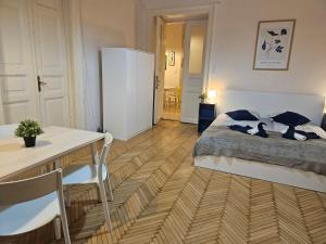 1 dormitorio con 1 cama, mesa y sillas en Chic Central Rooms, en Budapest