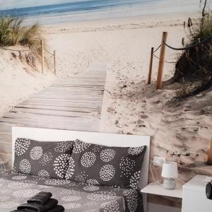 a couch sitting on a beach next to a wooden boardwalk at b&b Casa Balai 72 a 150 mt dal mare in Porto Torres