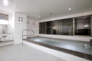 a bath room with a tub and a sink at Hotel Sunoak Kashiwanoha in Kashiwa