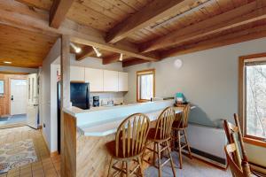 eine Küche mit Holzdecken und eine Bar mit Stühlen in der Unterkunft Trail's End in Thornton