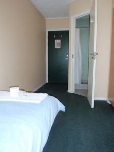 a bedroom with a white bed and a green door at James Lighthill House, Finsbury, London in London