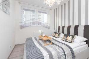 a living room with a bed and a table at Cozy Apartment Gdańsk Morena Rakoczego by Rent like home in Gdańsk