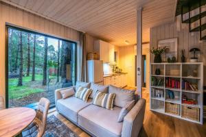 a living room with a couch and a table at Heban Forest Cabin&SAUNA Starlink in Tomczyn