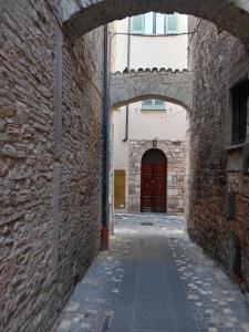 an alley with an archway and a brown door at Camera Vacanze Lusitana C in Foligno